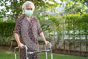 Asian senior or elderly old lady woman patient walk with walker in park,  healthy strong medical concept