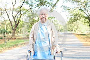 Asian senior or elderly old lady woman patient walk with walker in park, healthy strong medical.
