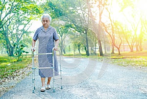 Asian senior or elderly old lady woman patient walk with walker in park : healthy strong medical concept