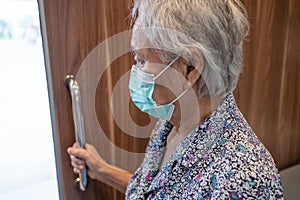 Asian senior or elderly old lady woman patient wearing face mask use toilet bathroom handle security in nursing hospital ward,