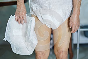 Asian senior or elderly old lady woman patient wearing incontinence diaper in nursing hospital