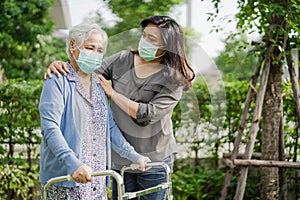 Asian senior or elderly old woman walk with walker and wearing a face mask for protect safety infection Covid-19 Coronavirus
