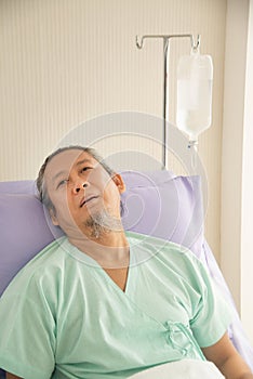 Asian senior or elderly old male patient lie down handle the bed with hope on a bed in the hospital.