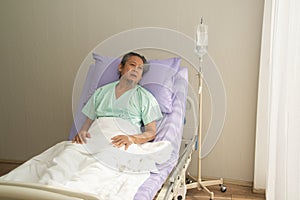 Asian senior or elderly old male patient lie down handle the bed with hope on a bed in the hospital.