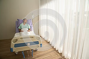 Asian senior or elderly old male patient lie down handle the bed with hope on a bed in the hospital.