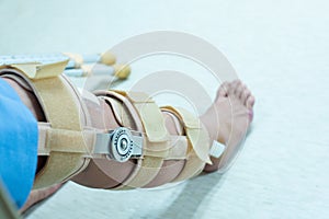 Asian senior or elderly old woman patient with bandage compression knee brace support injury on the bed in nursing hospital.