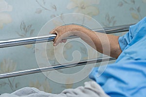 Asian senior or elderly old woman patient lie down handle the rail bed