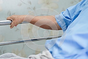 Asian senior or elderly old woman patient lie down handle the rail bed with hope on a bed