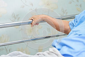 Asian senior or elderly old woman patient lie down handle the rail bed with hope on a bed in hospital