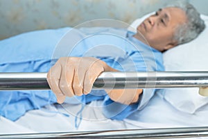 Asian senior or elderly old woman patient lie down handle the rail bed with hope in the hospital