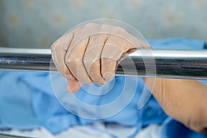 Asian senior or elderly old woman patient lie down handle the rail bed with hope on a bed in the hospital