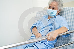 Asian senior or elderly old woman patient lie down handle the rail bed with hope on a bed in the hospital
