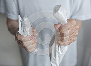 Asian senior or elderly woman patient holding medicine pills with both hand.