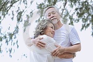 Asian senior Happy retired couple, relax smiling elder man and woman enjoying with retired vacation at sea beach outdoor. Health