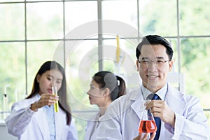 Asian senior laboratory scientist man working at lab with asian young student scientist backgroud