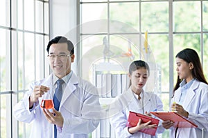 Asian senior laboratory scientist man working at lab with asian young student scientist backgroud