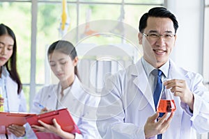 Asian senior laboratory scientist man working at lab with asian young student scientist backgroud
