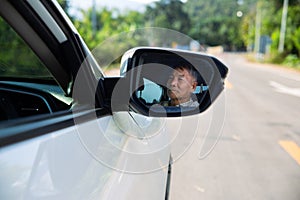 Asian senior man driving car