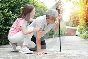 Asian senior man falling down at home in the backyard caused by myasthenia Muscle Weakness and the nurse came to help support.