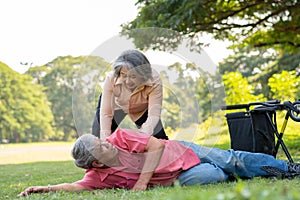 Asian senior man falling down from wheelchair on lying floor after trying push the wheelchair forward and Crying in pain and