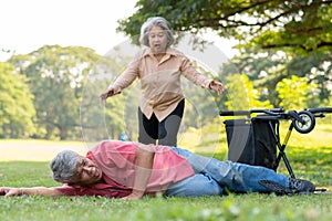 Asian senior man falling down from wheelchair on lying floor after trying push the wheelchair forward and Crying in pain and