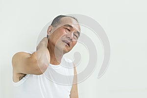 Asian senior man having pain on his shoulder and neck. copy space.