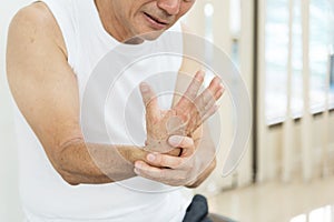 Asian senior man having wrist pain or injury