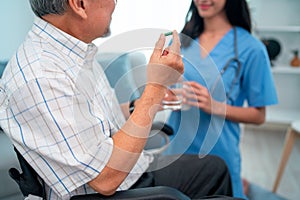 Asian senior man hold medicine pill and discuss with nurse or doctor during homecare service