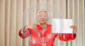 Asian Senior man holding sign with copy space for Chinese new year surprise deal