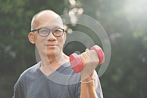 Asian Senior man lifting dumbbell