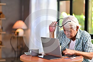 Asian senior man looking confuse when using credit card for online shopping