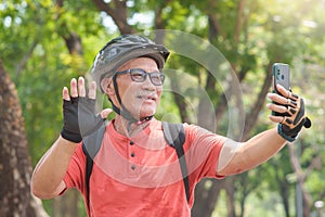 Asian Senior man making video call while travel with bicycle