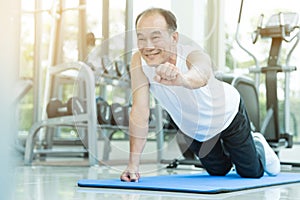 Asian senior man push up at the gym.