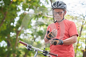 Asian Senior Man putting bicycle gloves