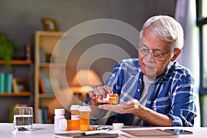 Asian senior man taking medicine at home