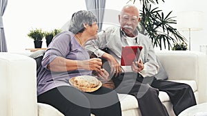 Asian senior man using tablet computer and Senior woman hand craft knitting wool at home.