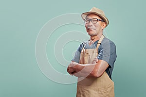 Asian Senior man wearing brown apron with arms crossed