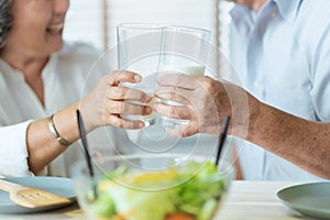 Asian senior man and woman drinking milk and having breakfast