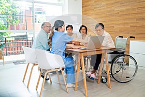 Asian senior man and woman enjoy to talk and fun with activity of nurse or doctor during teach with laptop on table in living room