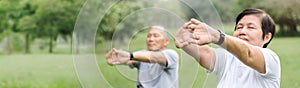 Asian Senior man and woman stretching hands and arms before exercise at park. Happy elderly couple enjoying workout at outdoor in
