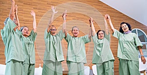 Asian senior men and women raise their hands up and express of happiness together with concept of good health and cheerful for