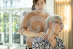 Asian senior mother have nerve pain,shoulder ache,neck pains,female caregiver or daughter massaging her shoulders, frustrated