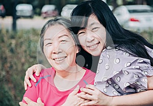 Asian senior mother and her adult daughter are hugging