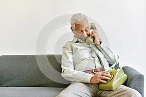 Asian senior old man telephone call their children, Lonely grandfather  talking with family on vintage phone at home.
