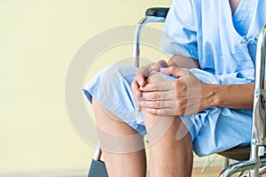 Asian senior patient wheelchair with knee pain