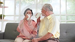 Asian senior retired couple drinking glasses of milk for calcium healthy nutrition.
