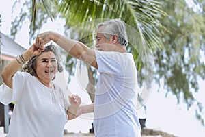 Asian senior retired couple, relax smiling elder man and woman enjoying with retired vacation at sea beach outdoor. Health