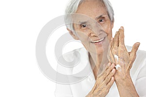 Asian senior woman applying baby lotion on hands,rubbing her palm with hands cream,moisturizer cream used to prevent dryness, photo