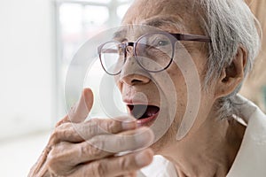 Asian senior woman checking breath with hand,old elderly doing a bad breath test,foul mouth from inside the tongue,teeth and gums