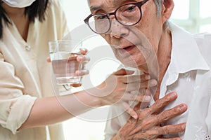 Asian senior woman coughing choking while drinking water or eating food,danger or risk of lung infection,disease of silent